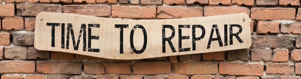 A Time To Repair sign hangs over a brick wall background reminding the reader that prompt repairs are crucial to preventing them again in the future as well as preventing full system replacements.